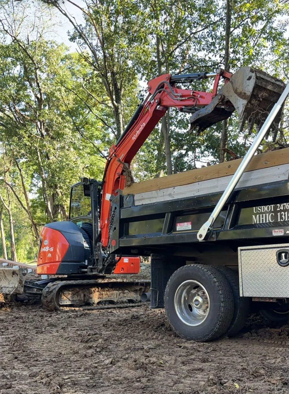 An excavator is loading dirt into a dump truck.