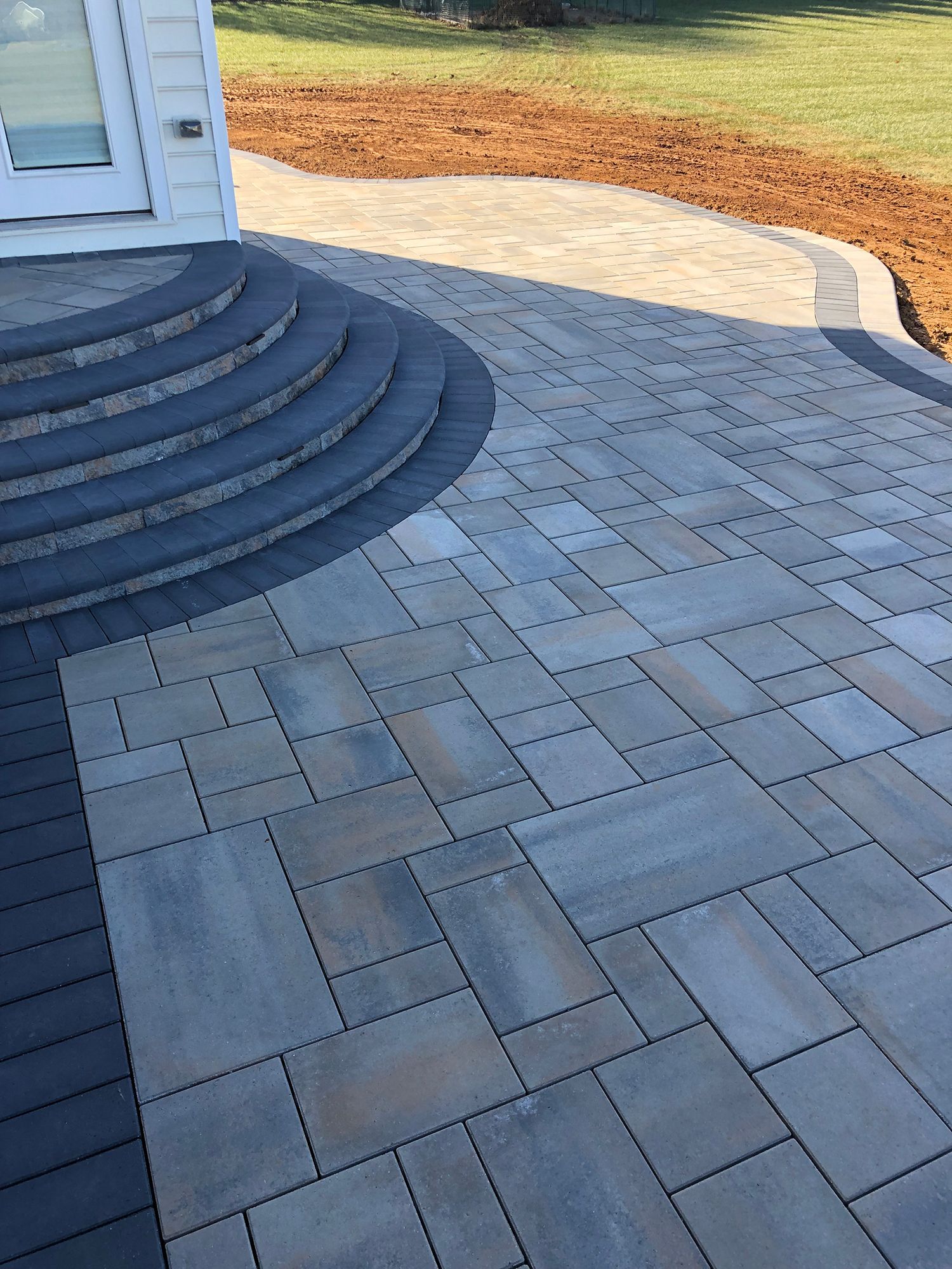 A patio with stairs leading up to a house.