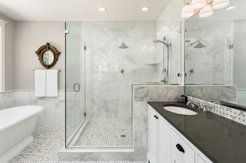 A bathroom with a tub, sink, mirror, and walk-in shower.