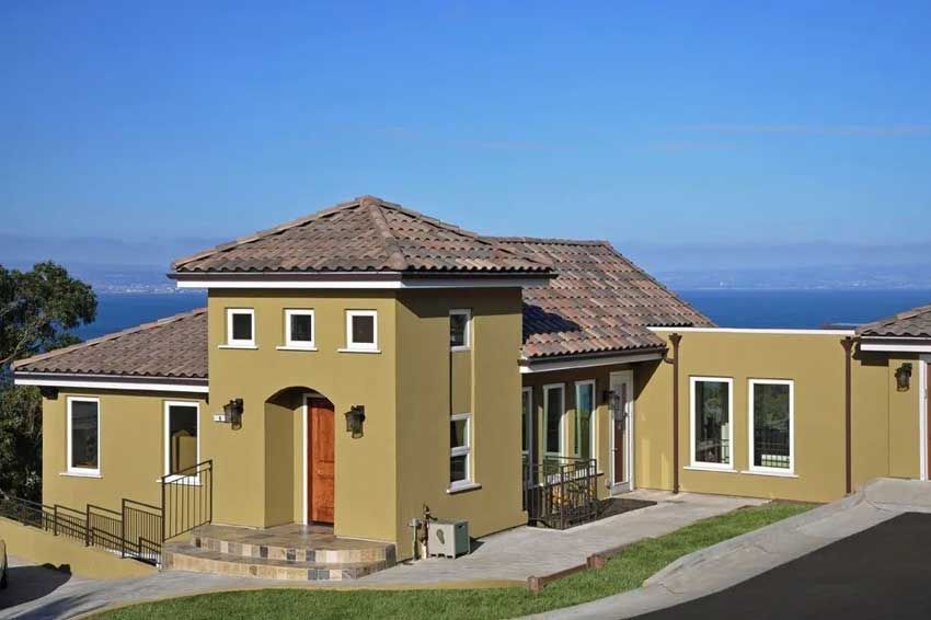 A large house with a tiled roof and a view of the ocean