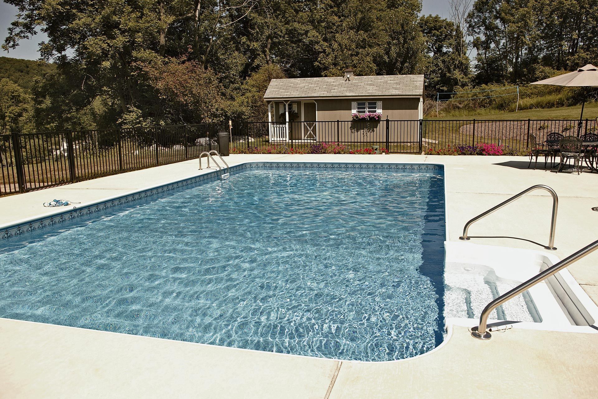 A large swimming pool with a house in the background