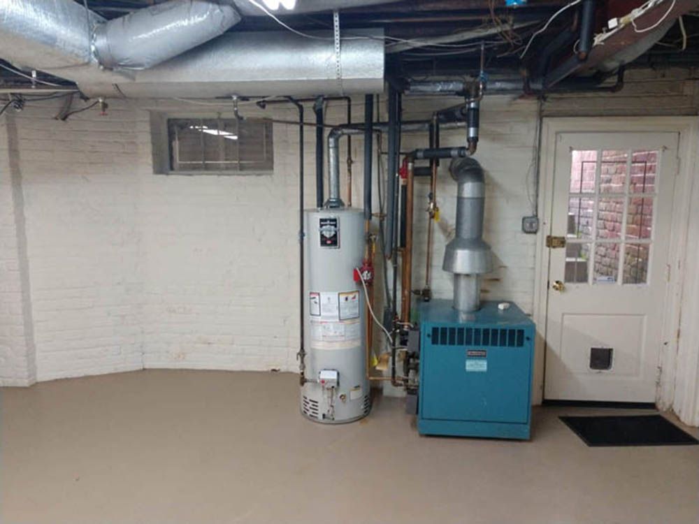 Basement utility room with water heater, furnace, exposed ductwork, and a white door.