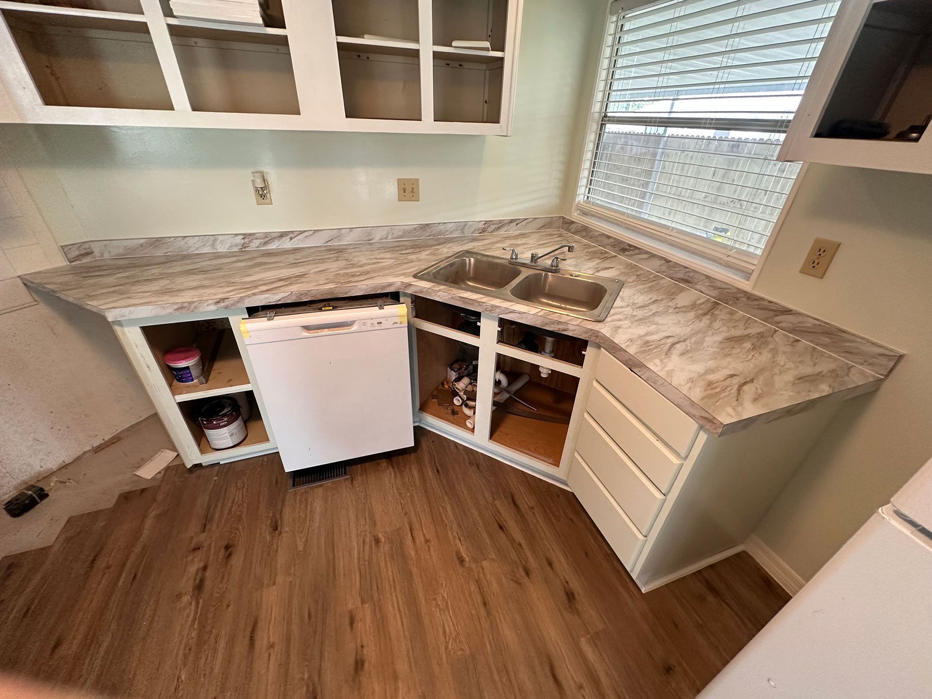 A kitchen with two sinks, a dishwasher, and a window