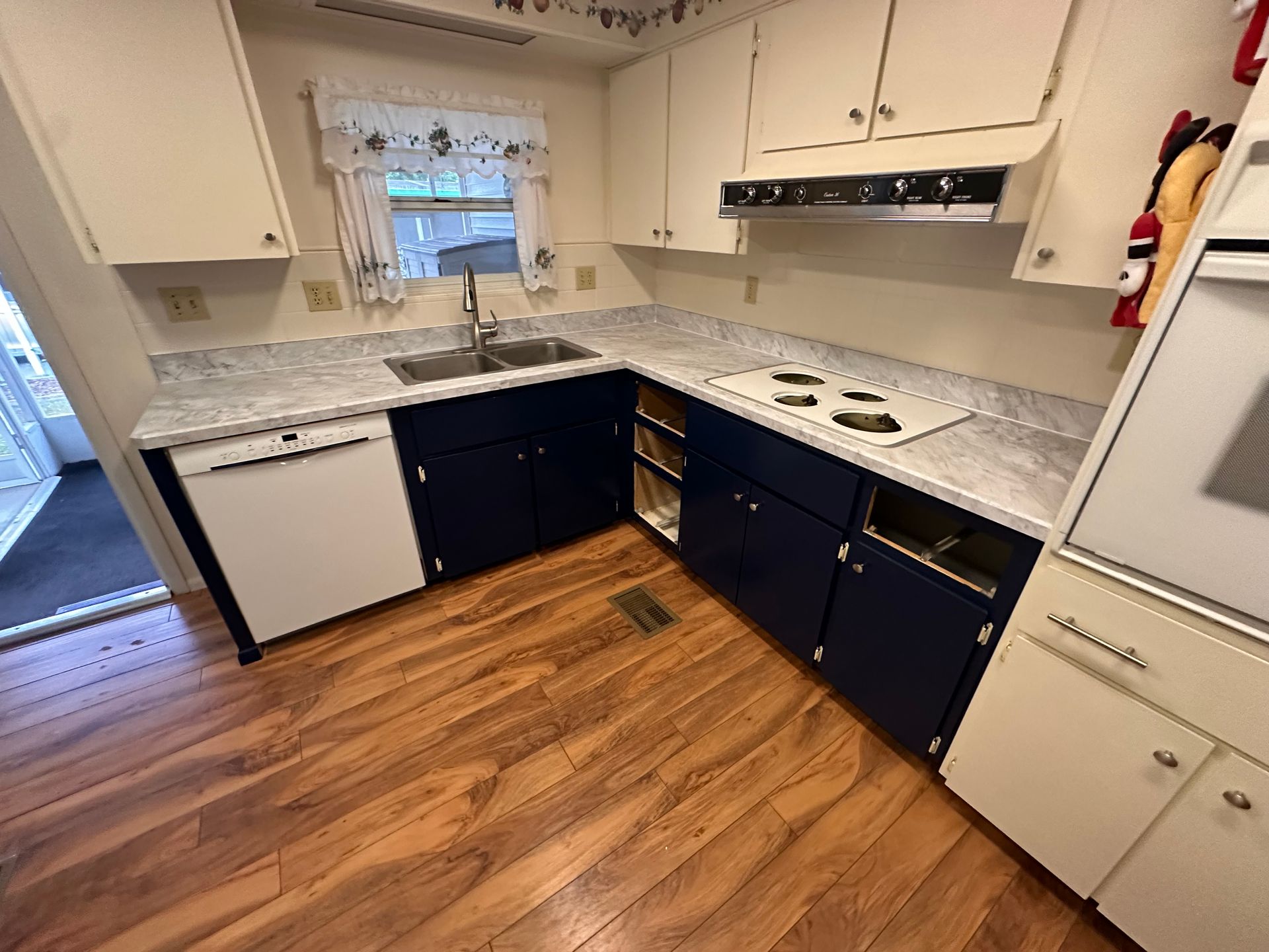 A kitchen with cabinets, a stove, a sink, and a dishwasher