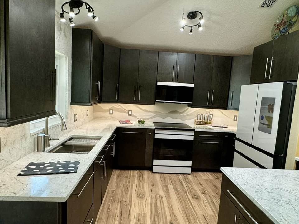A kitchen with black cabinets and white counter tops