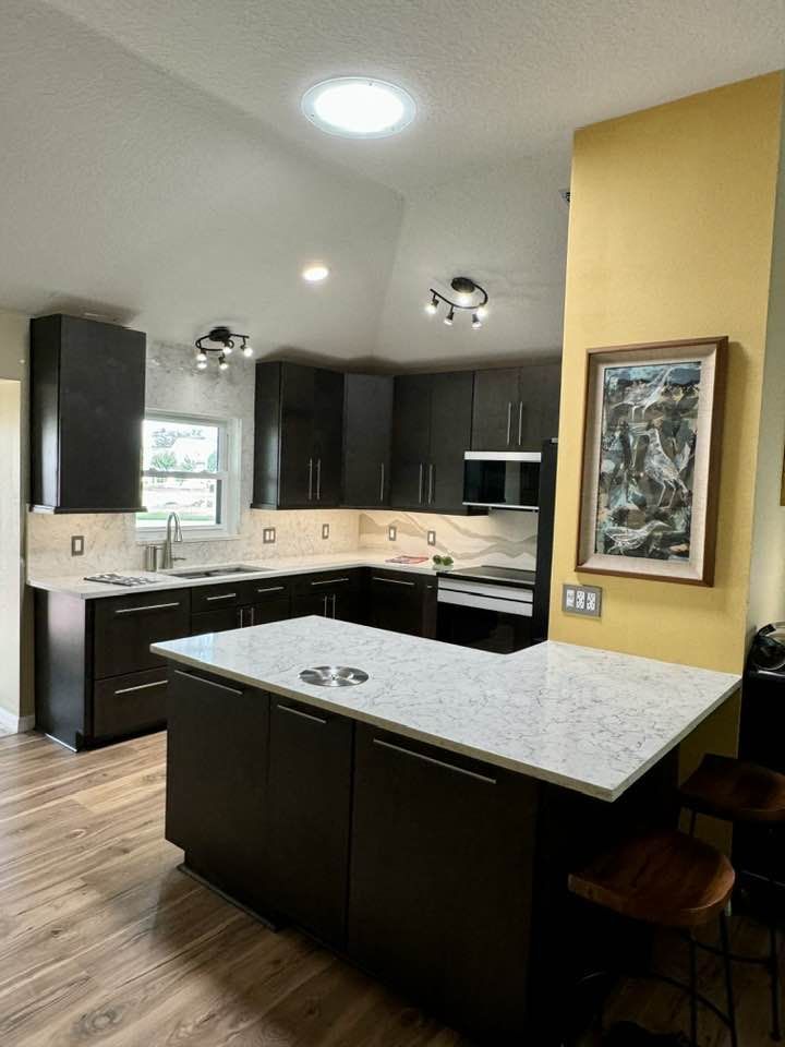 A kitchen with a large island and a picture on the wall