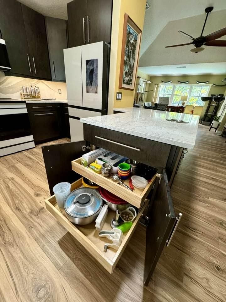 A kitchen with a pull-out drawer filled with pots and pans