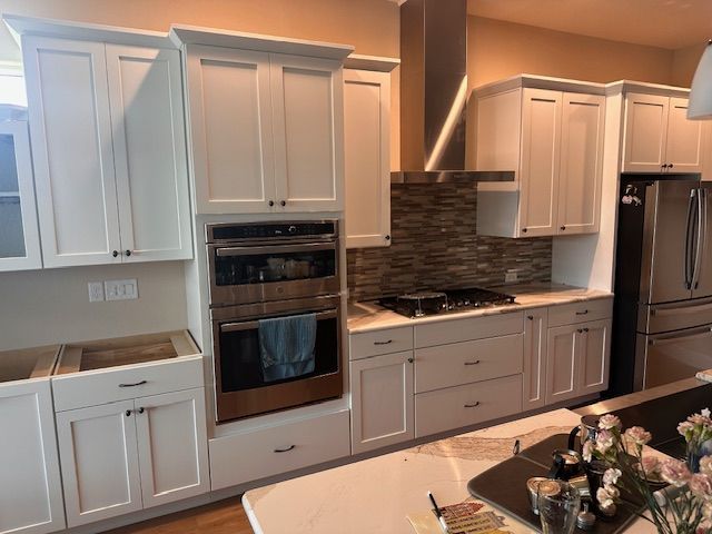A kitchen with white cabinets and stainless steel appliances.