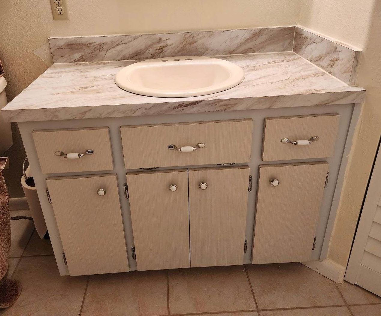 A bathroom vanity with a sink , drawers and cabinets.