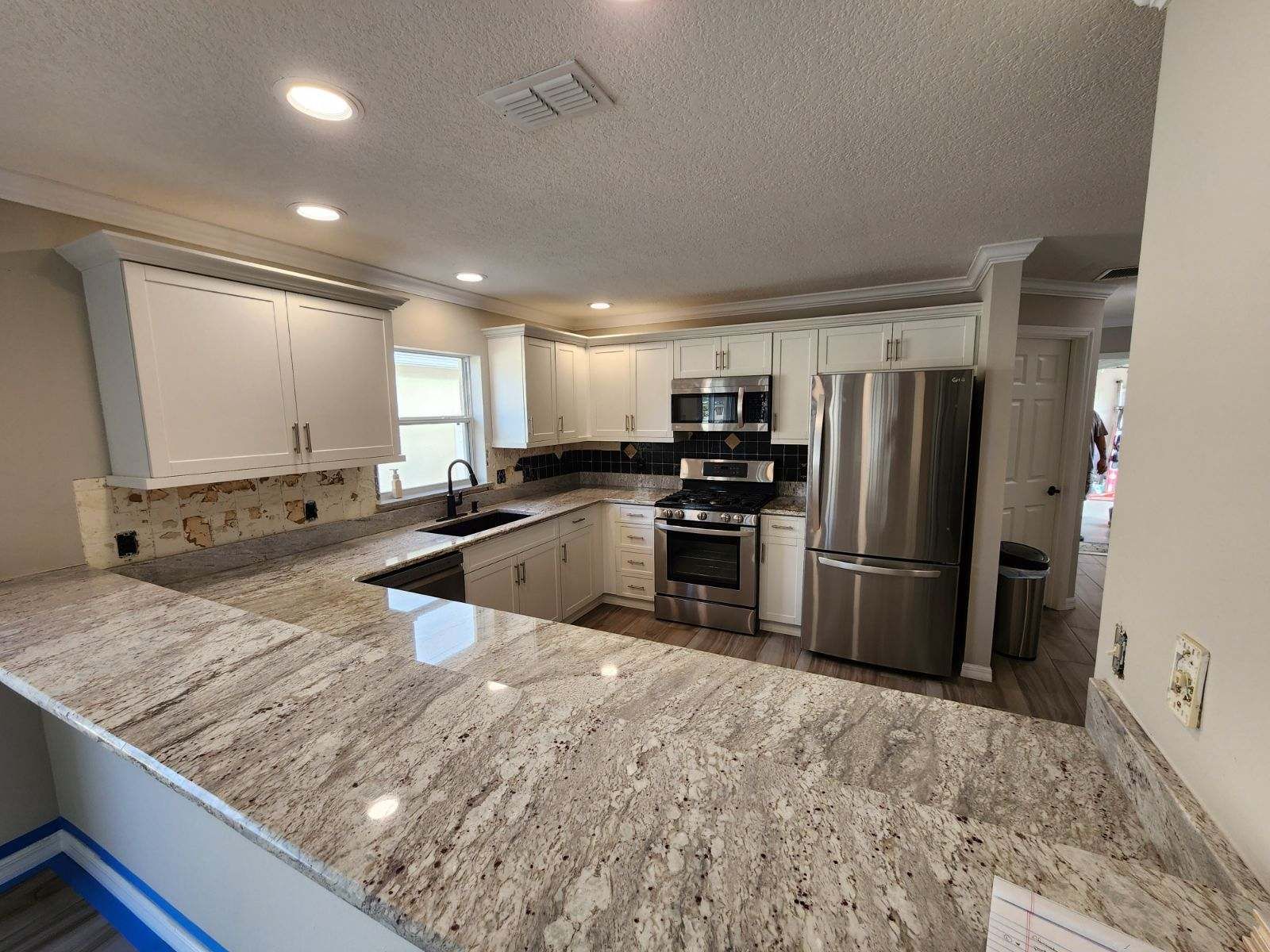 A kitchen with granite counter tops and stainless steel appliances