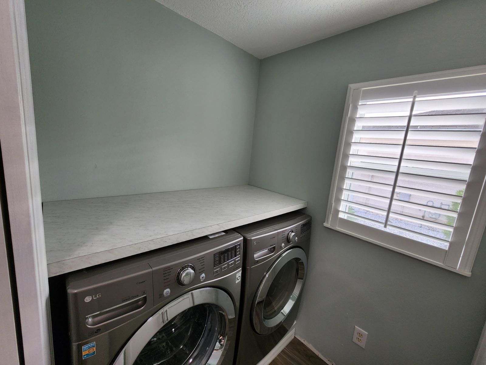 A laundry room with a washer and dryer and a window