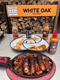 Grilled sausages and shrimp with various sauces and seasonings, outdoor setting.
