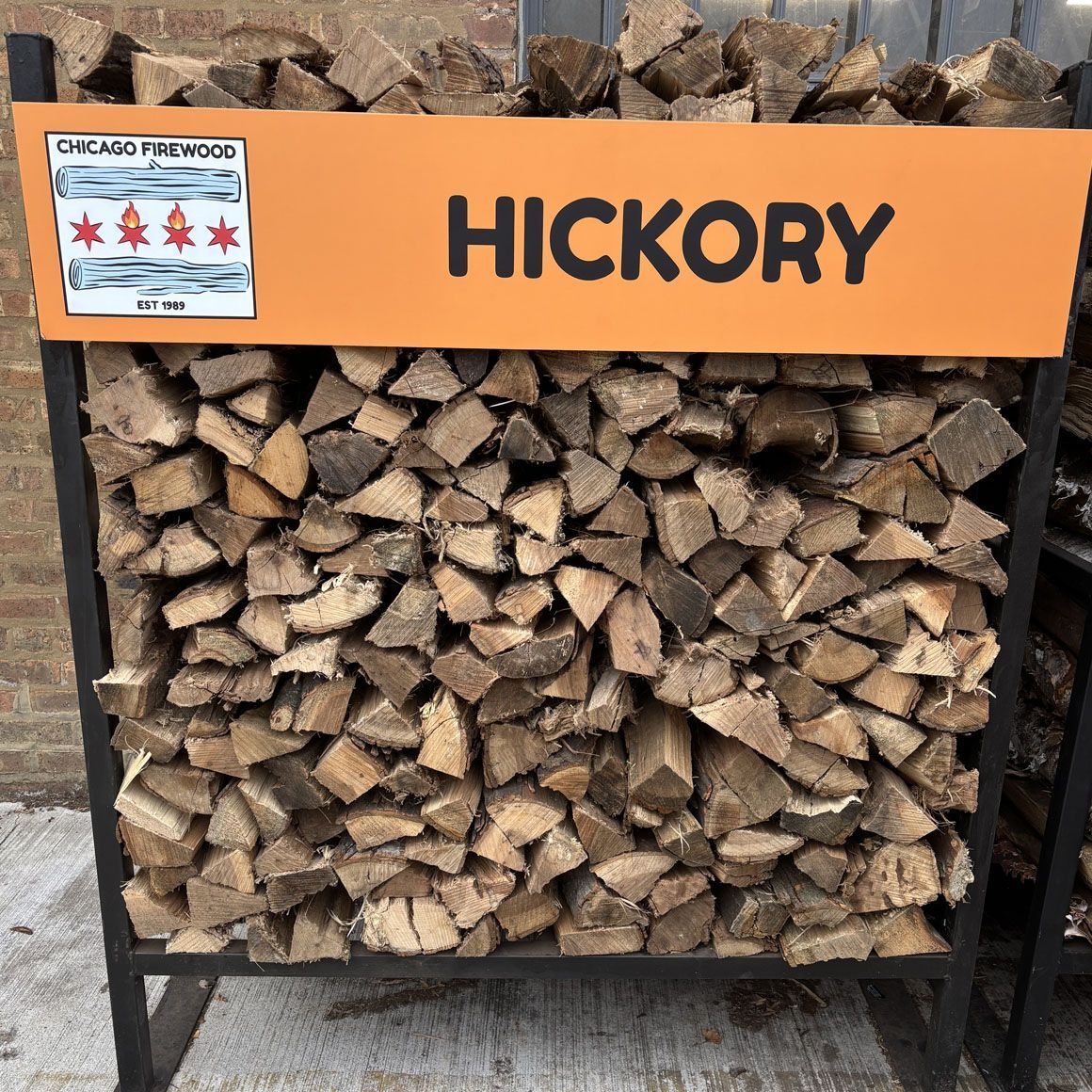 A rack of hickory firewood labeled with the Chicago Firewood logo and the word 