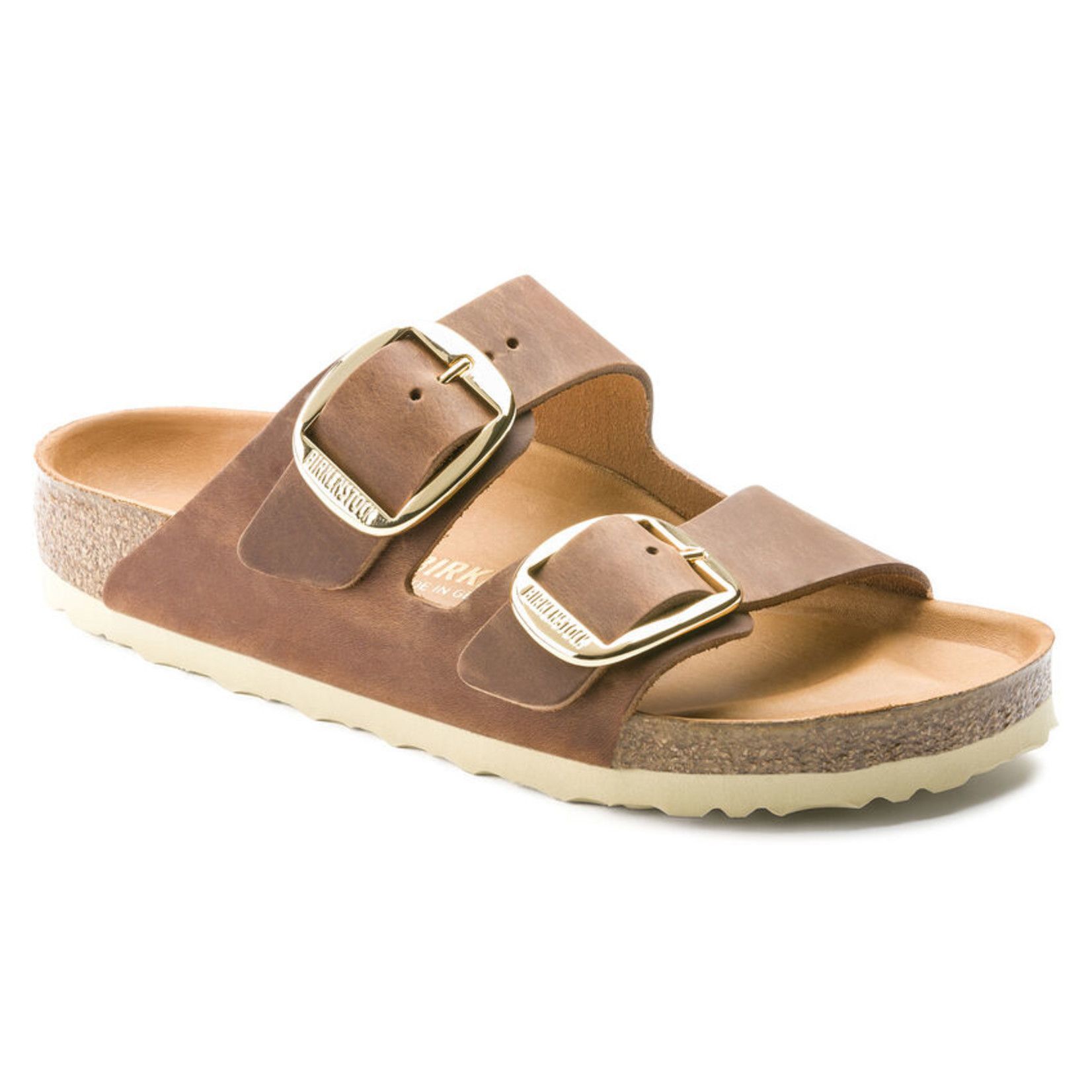 A pair of brown birkenstock sandals with gold buckles