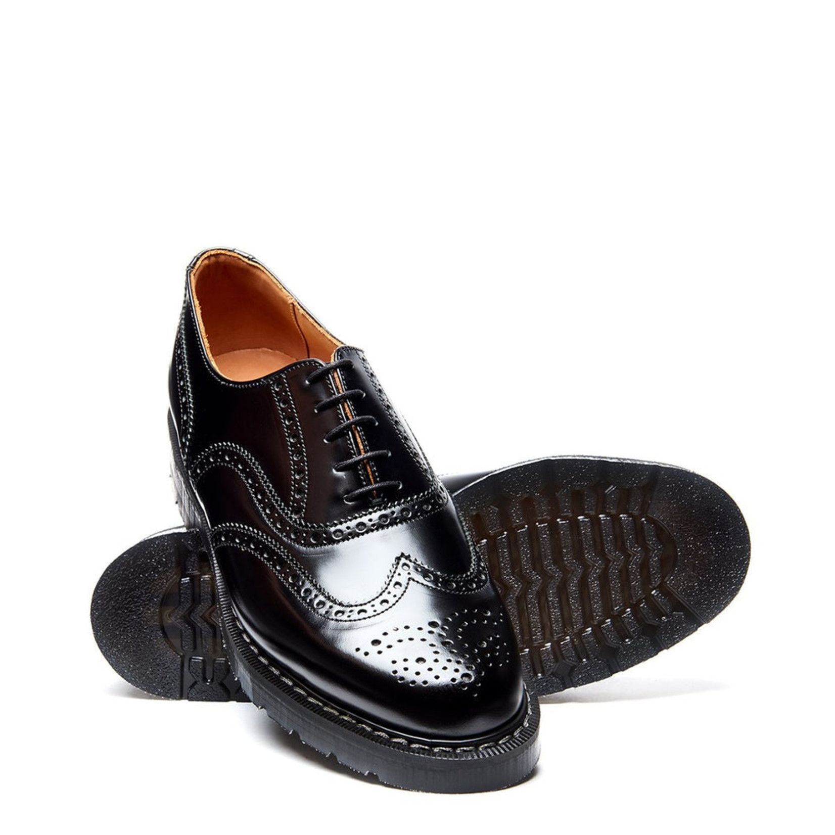 A pair of black brogue shoes on a white background