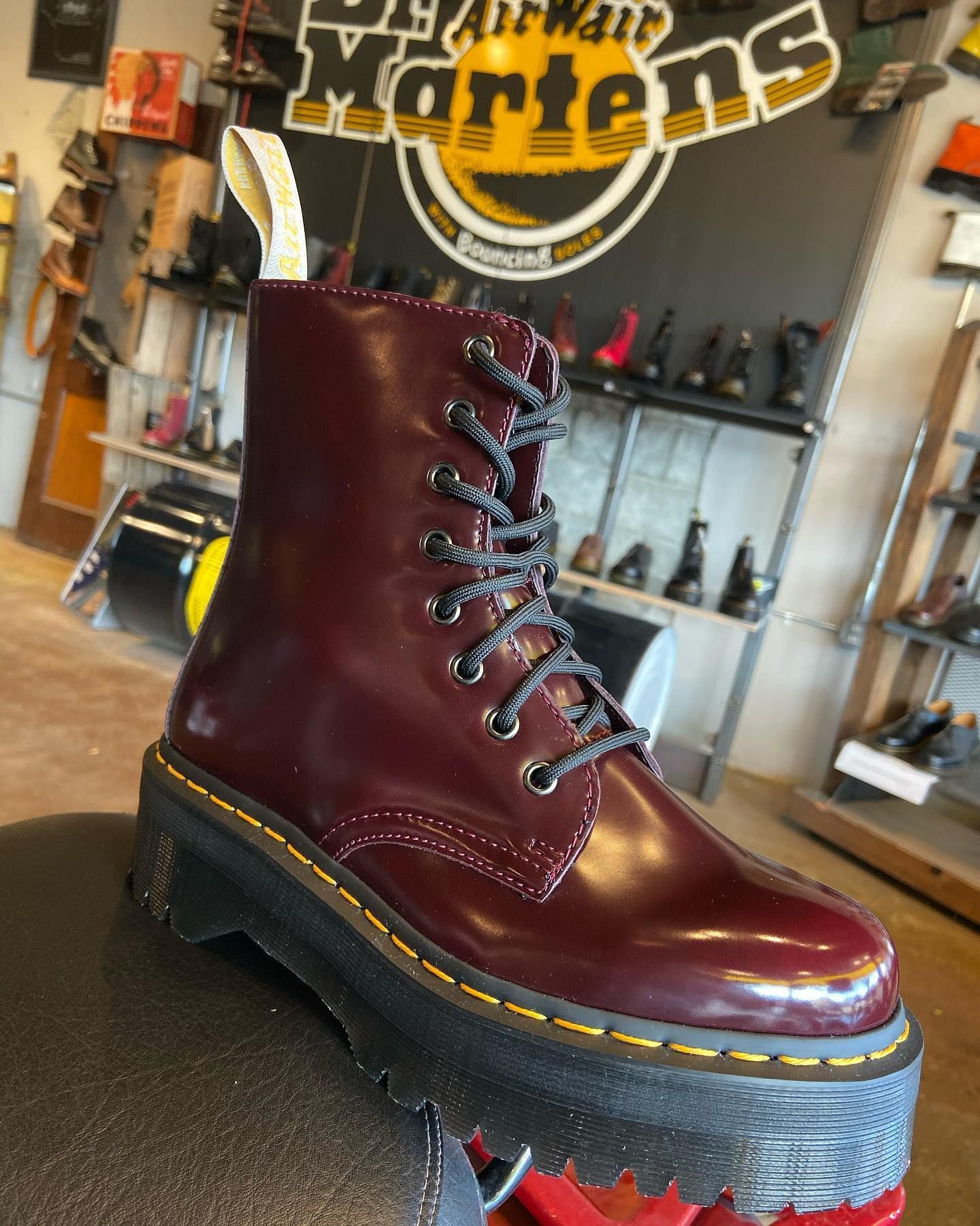 A pair of burgundy dr martens boots are on display in a store