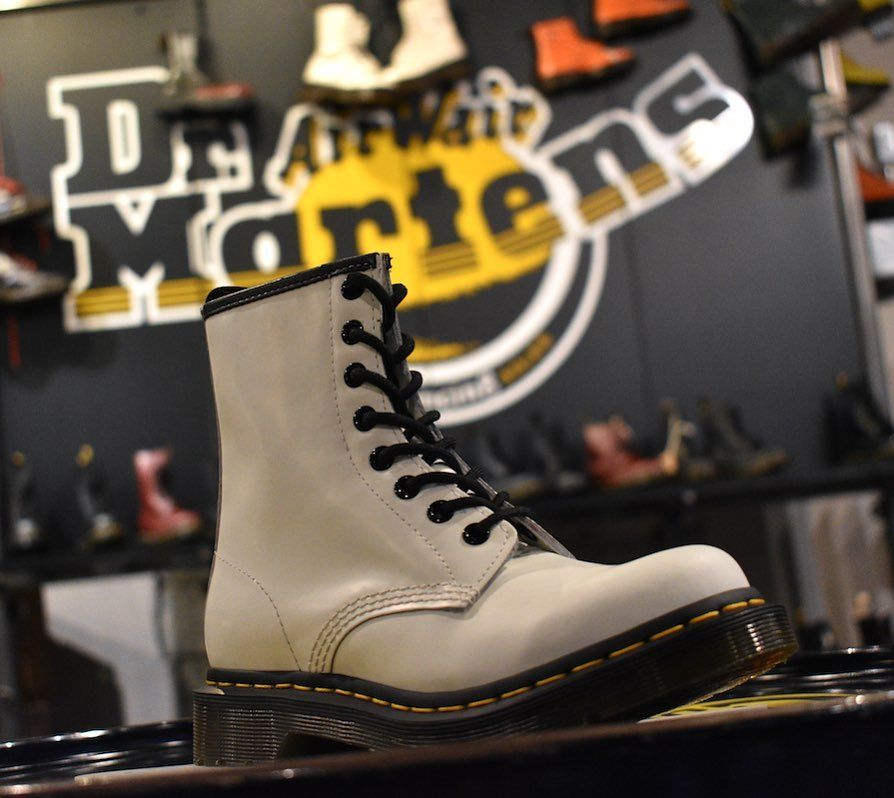 A pair of white dr martens boots on display in a store