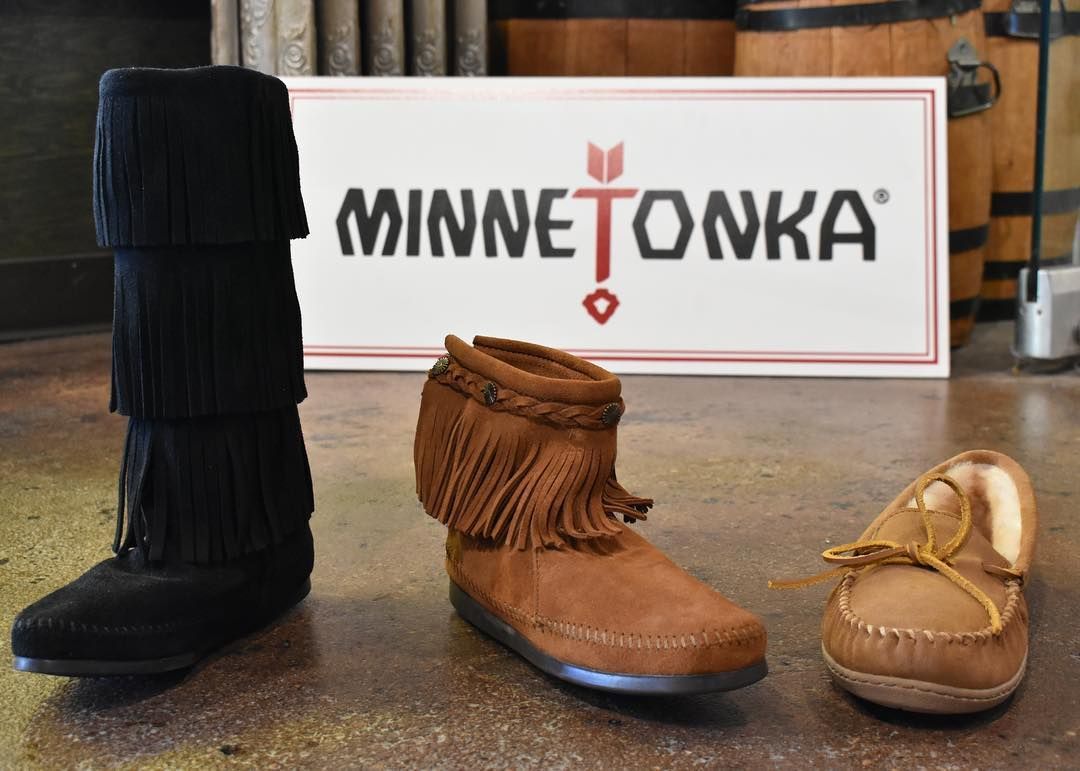 Three minnetonka boots and moccasins are on display on the floor