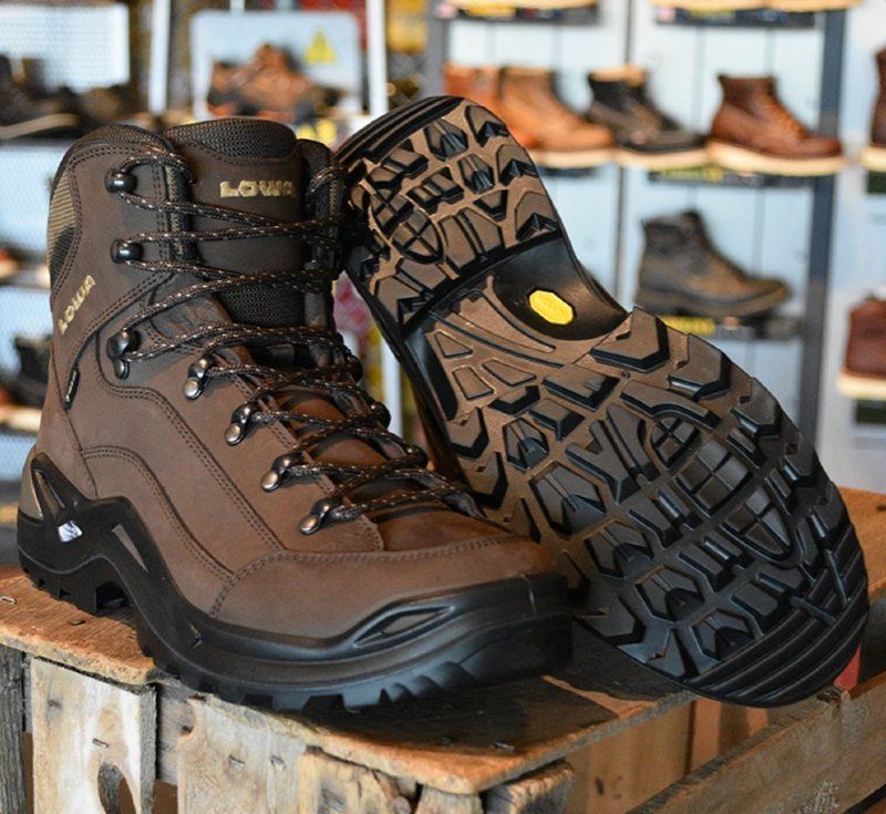 A pair of brown lowa boots are sitting on a wooden box