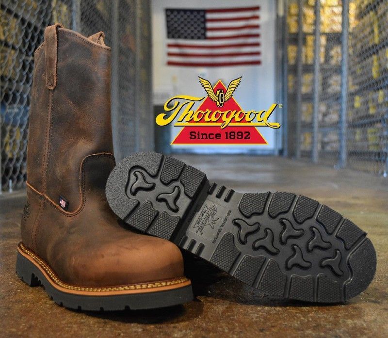 A pair of brown thorogood boots sitting on a concrete floor