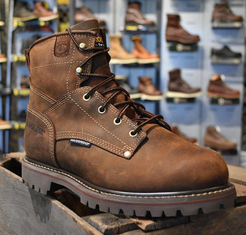 A pair of brown work boots sitting on a wooden box
