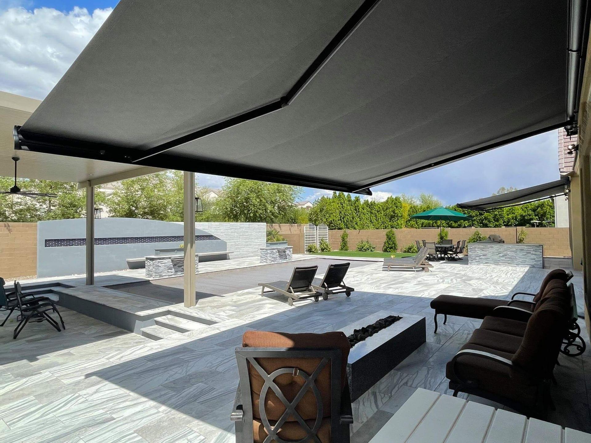 A patio with a black awning over it