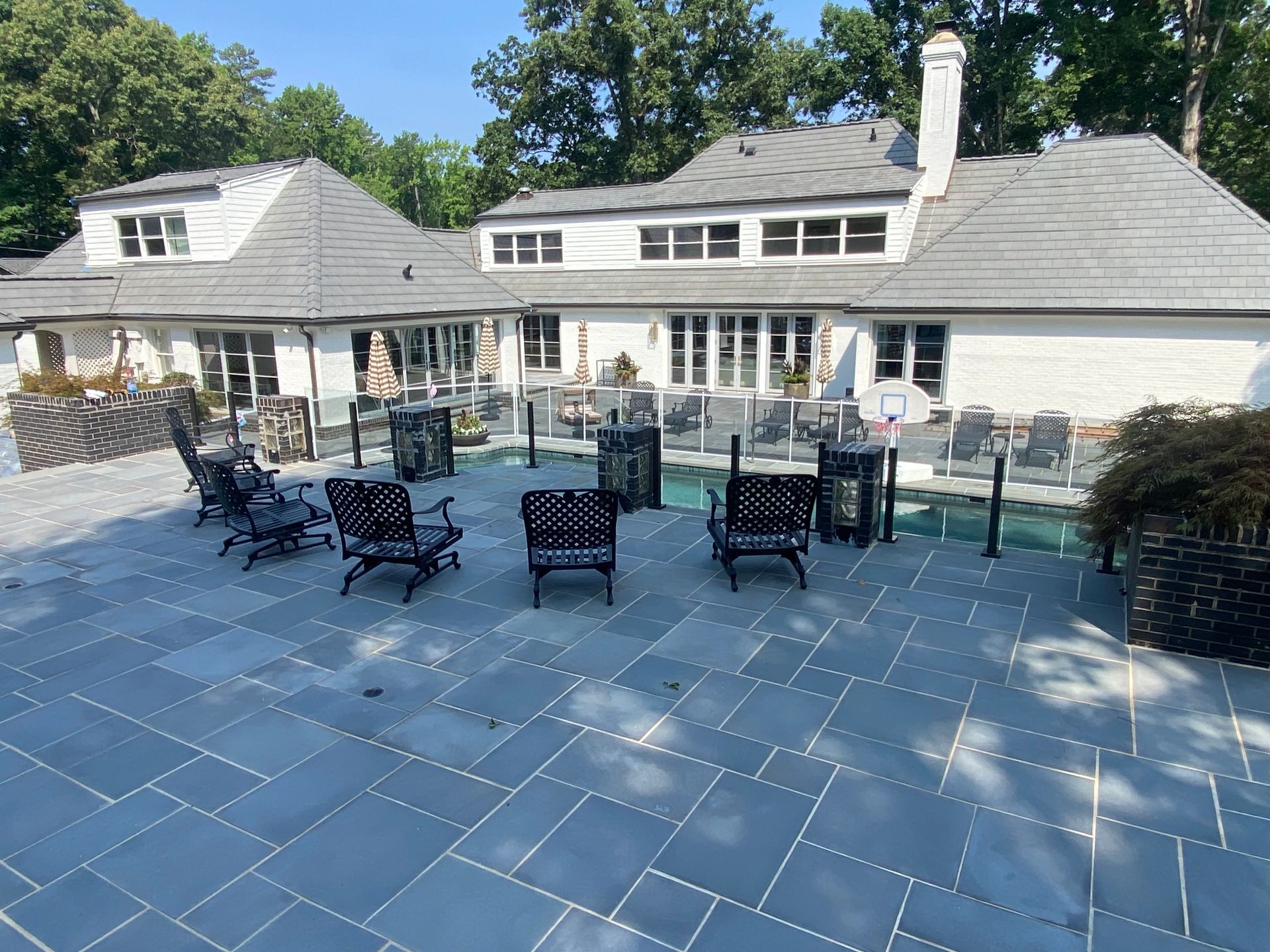 A large house with a patio and chairs in front of it.