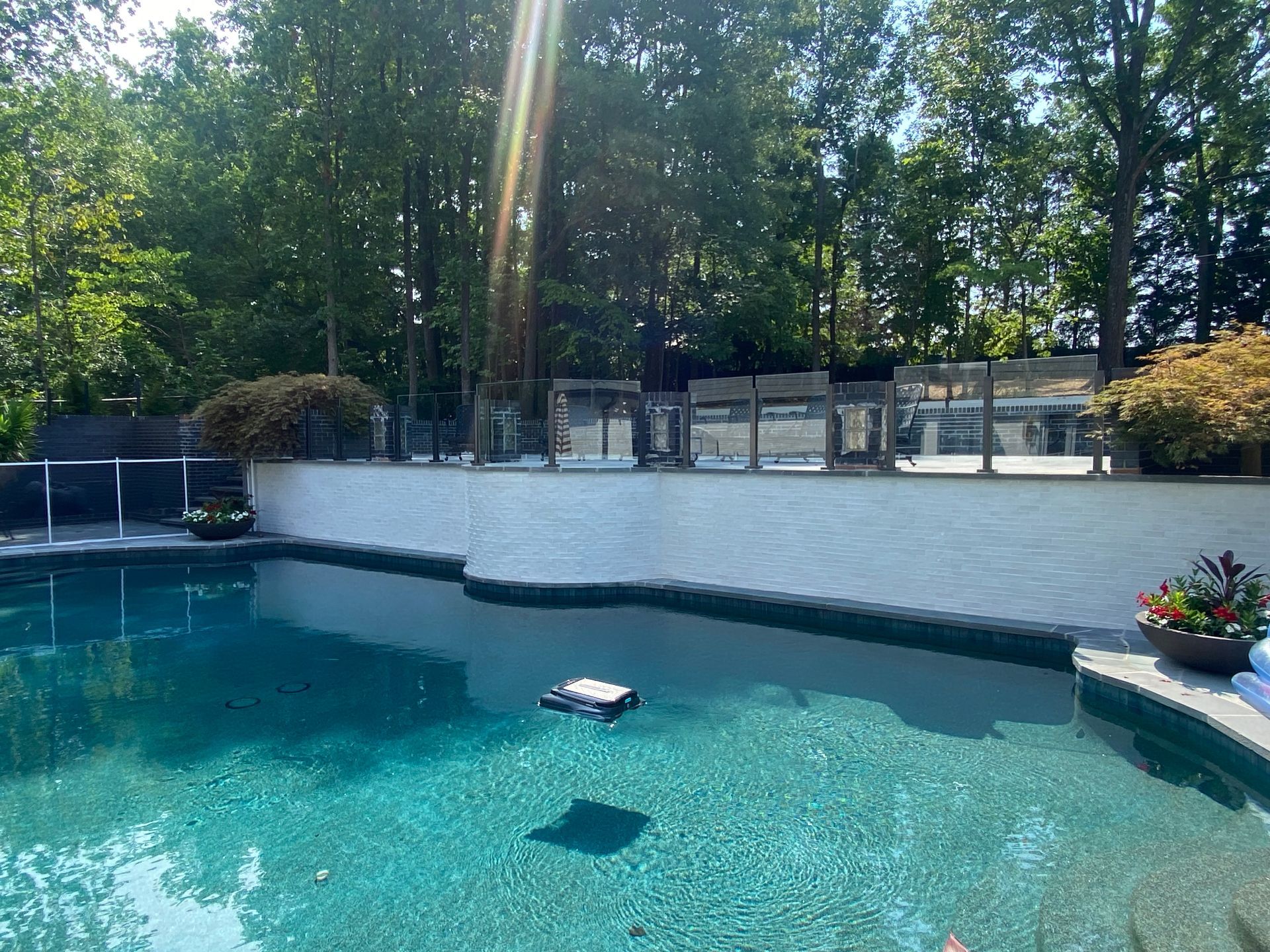A large swimming pool surrounded by trees on a sunny day