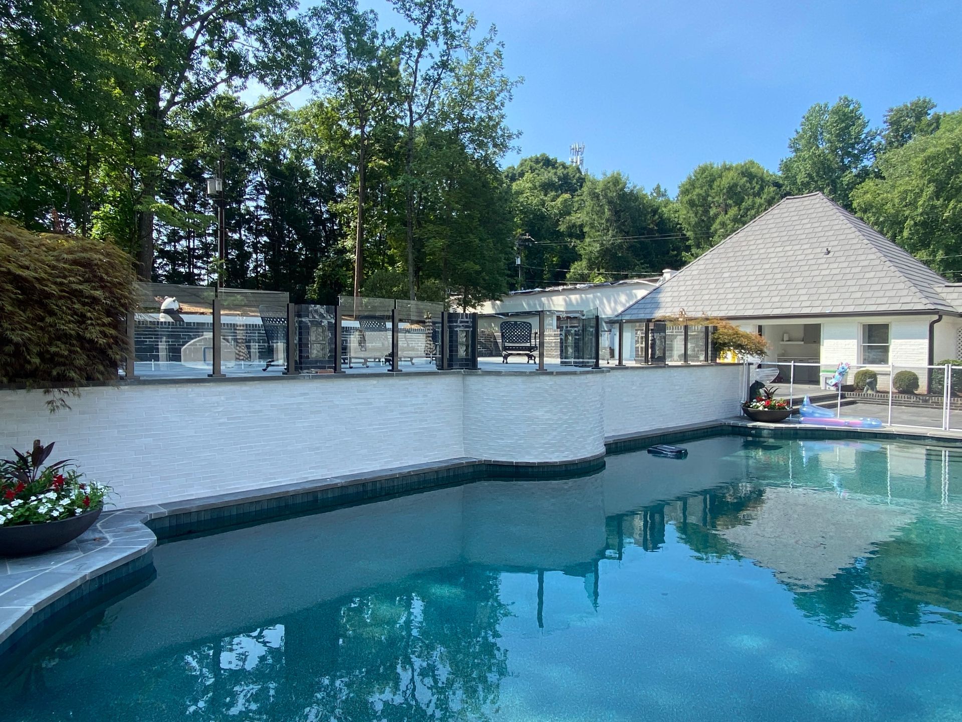 A large swimming pool with a house in the background