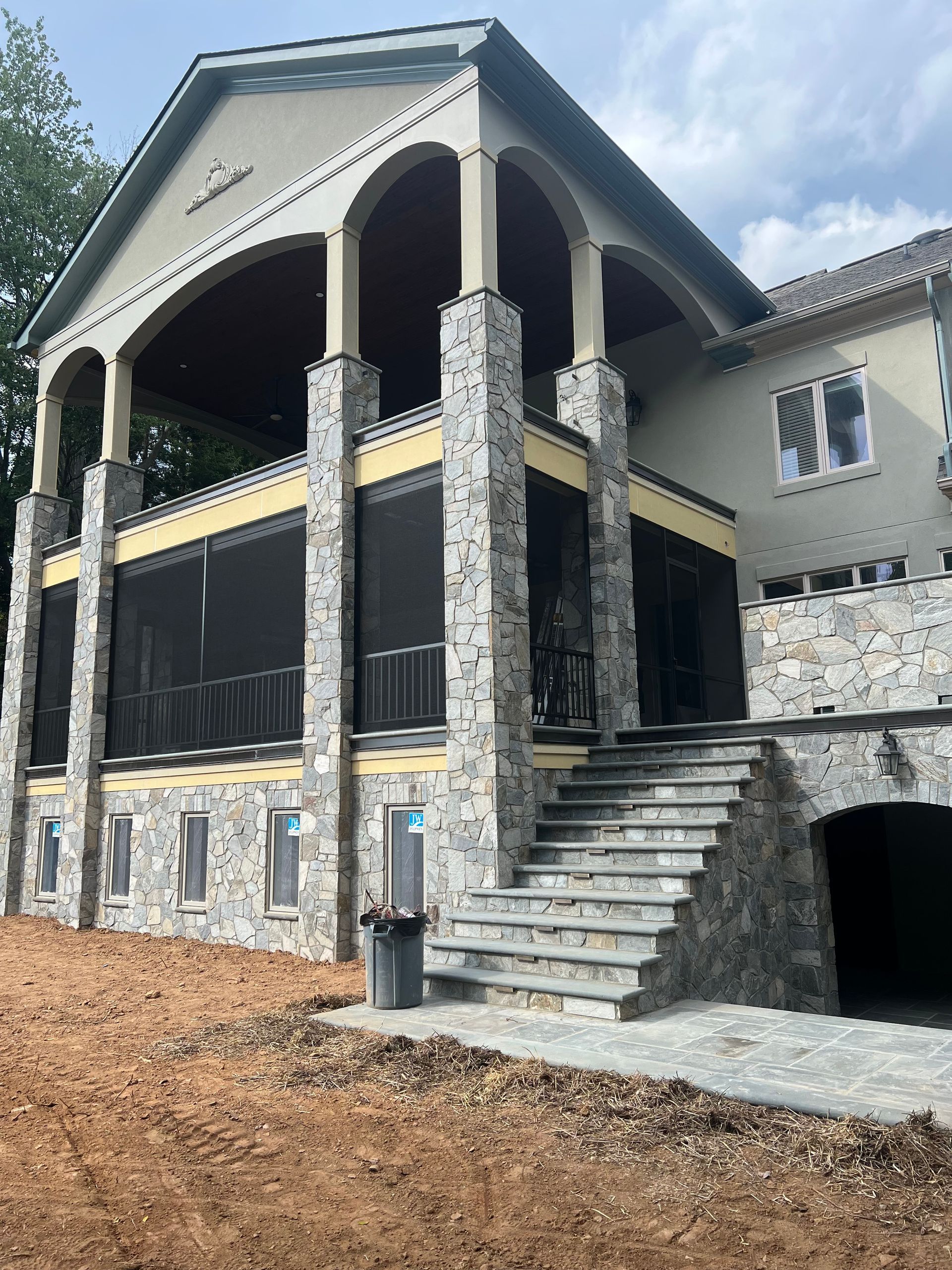 A large house with a screened in porch and stairs