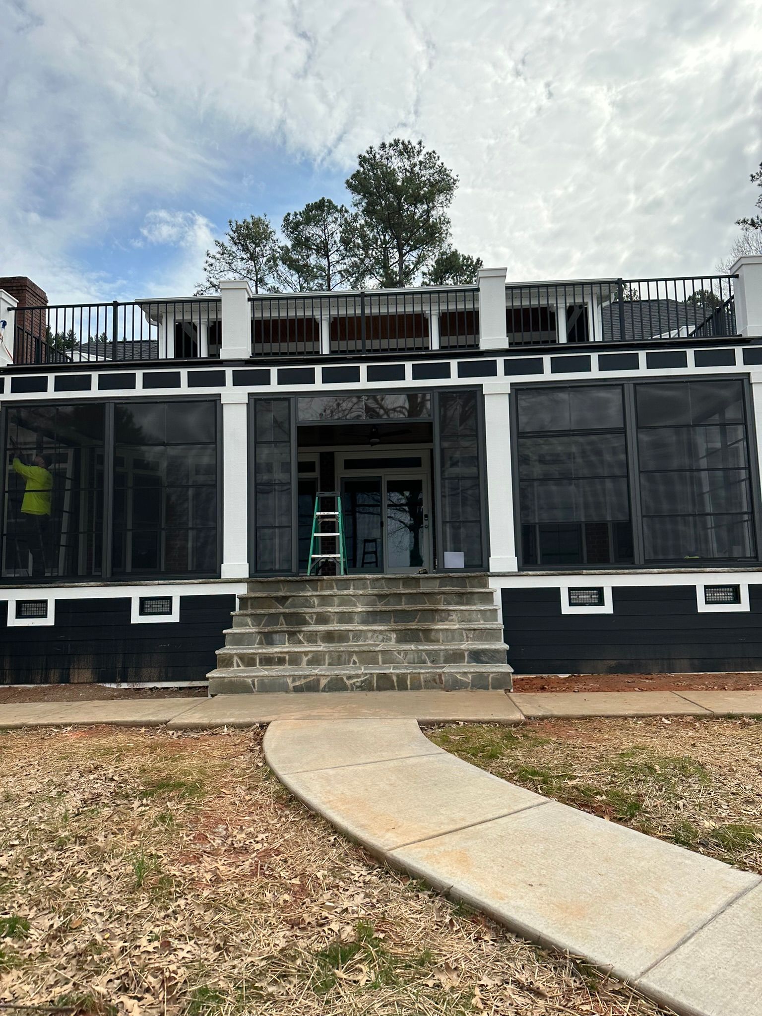 A large black and white house with a walkway leading to it