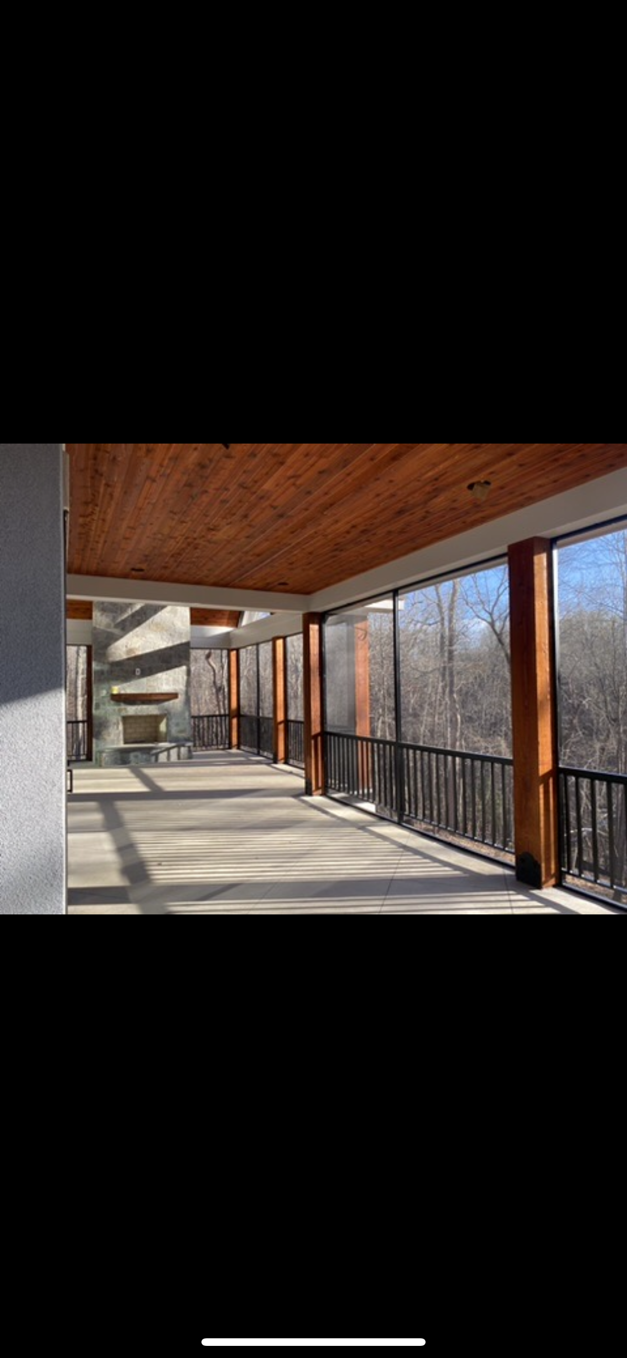A long hallway with lots of windows and a wooden ceiling