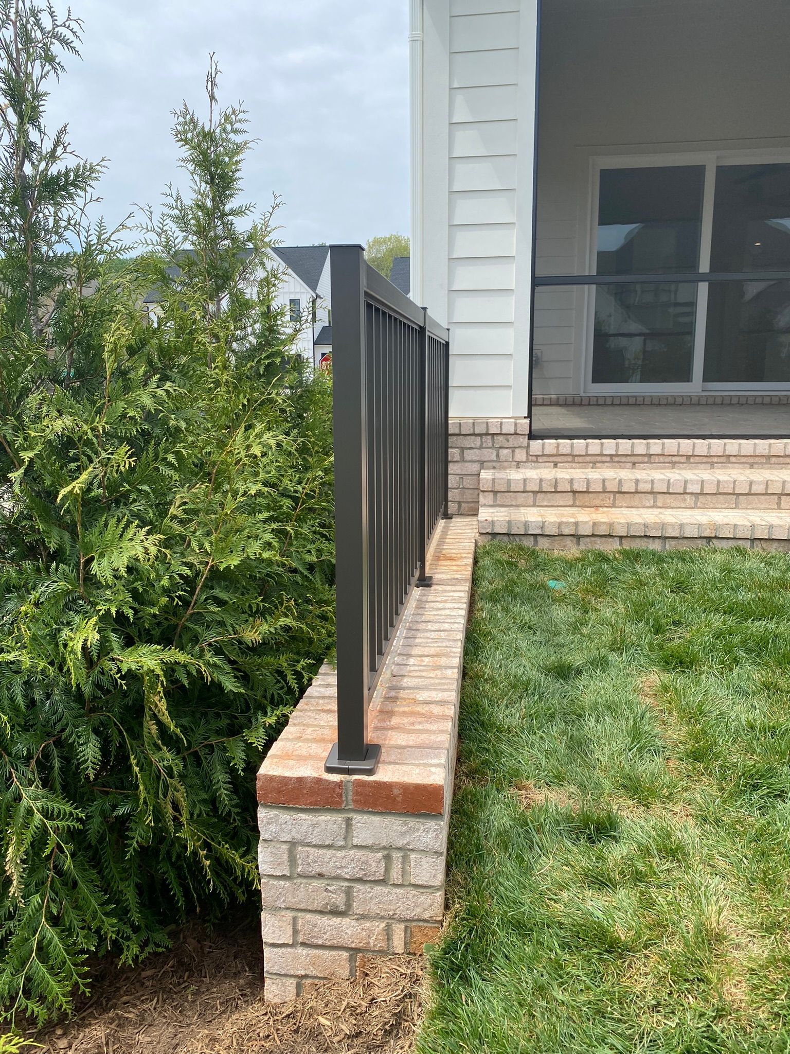 A brick wall with a railing in front of a house