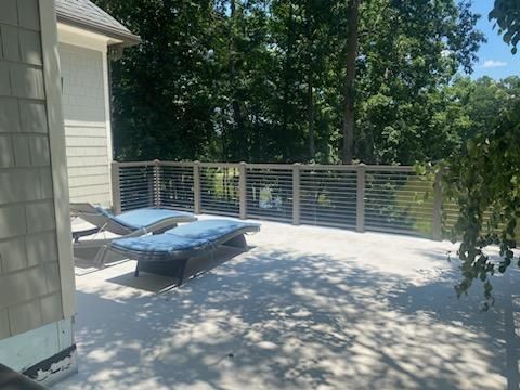 There are two lounge chairs on the deck of the house.