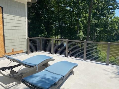 Two lounge chairs are sitting on a patio next to a fence.