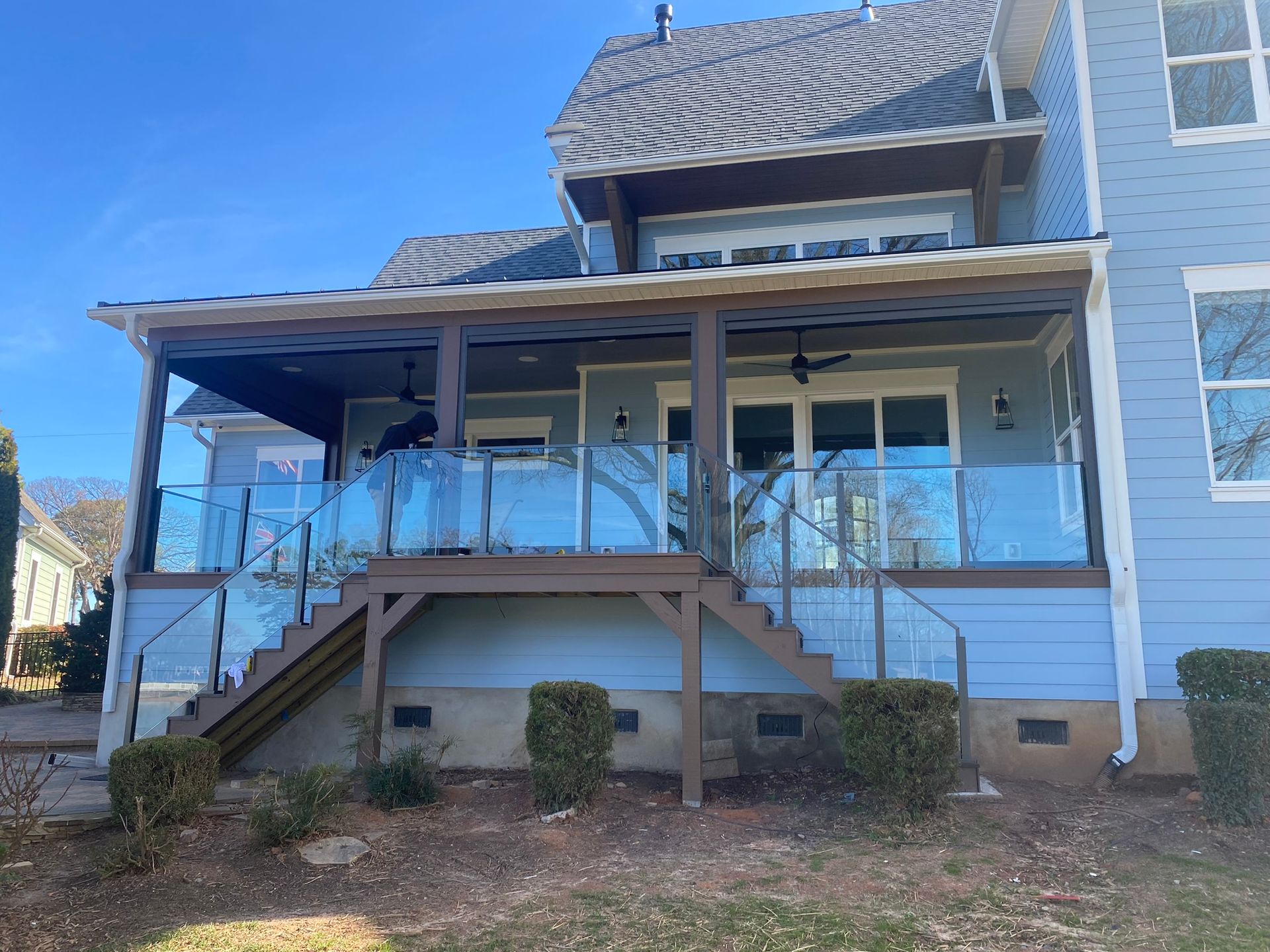A blue house with a glass deck and stairs