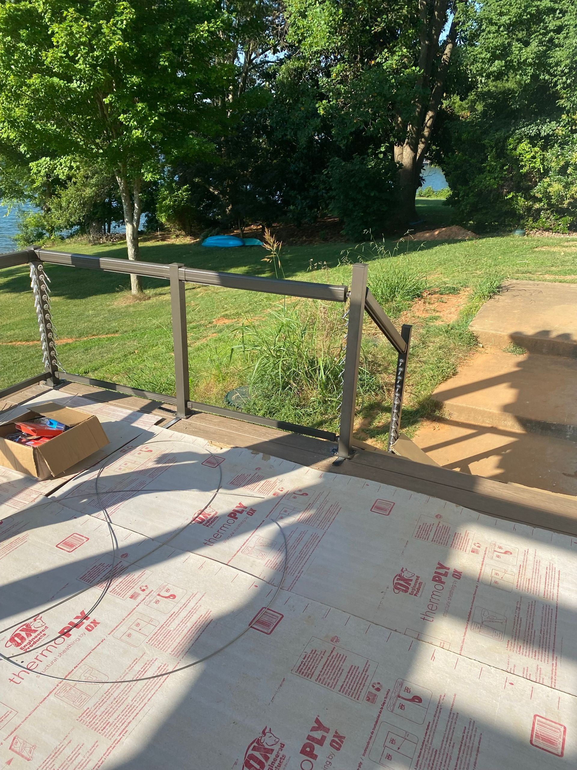 A patio with a wooden railing and a box on it.