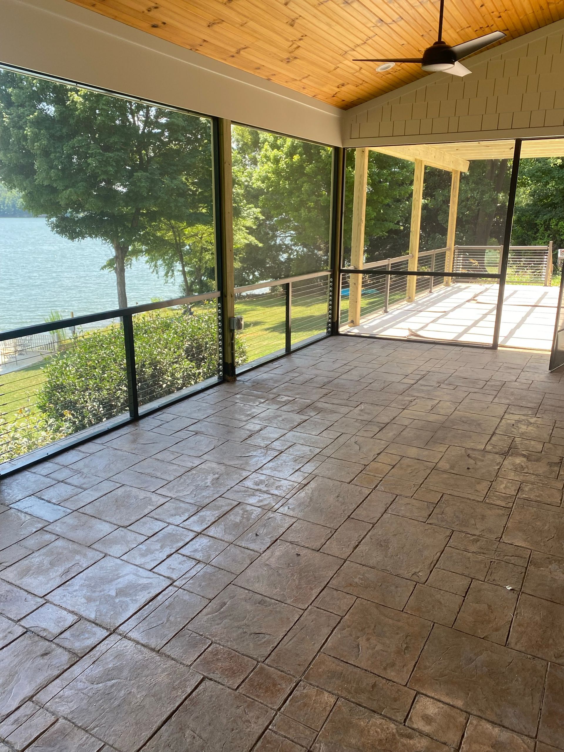 An empty screened-in porch with structural posts