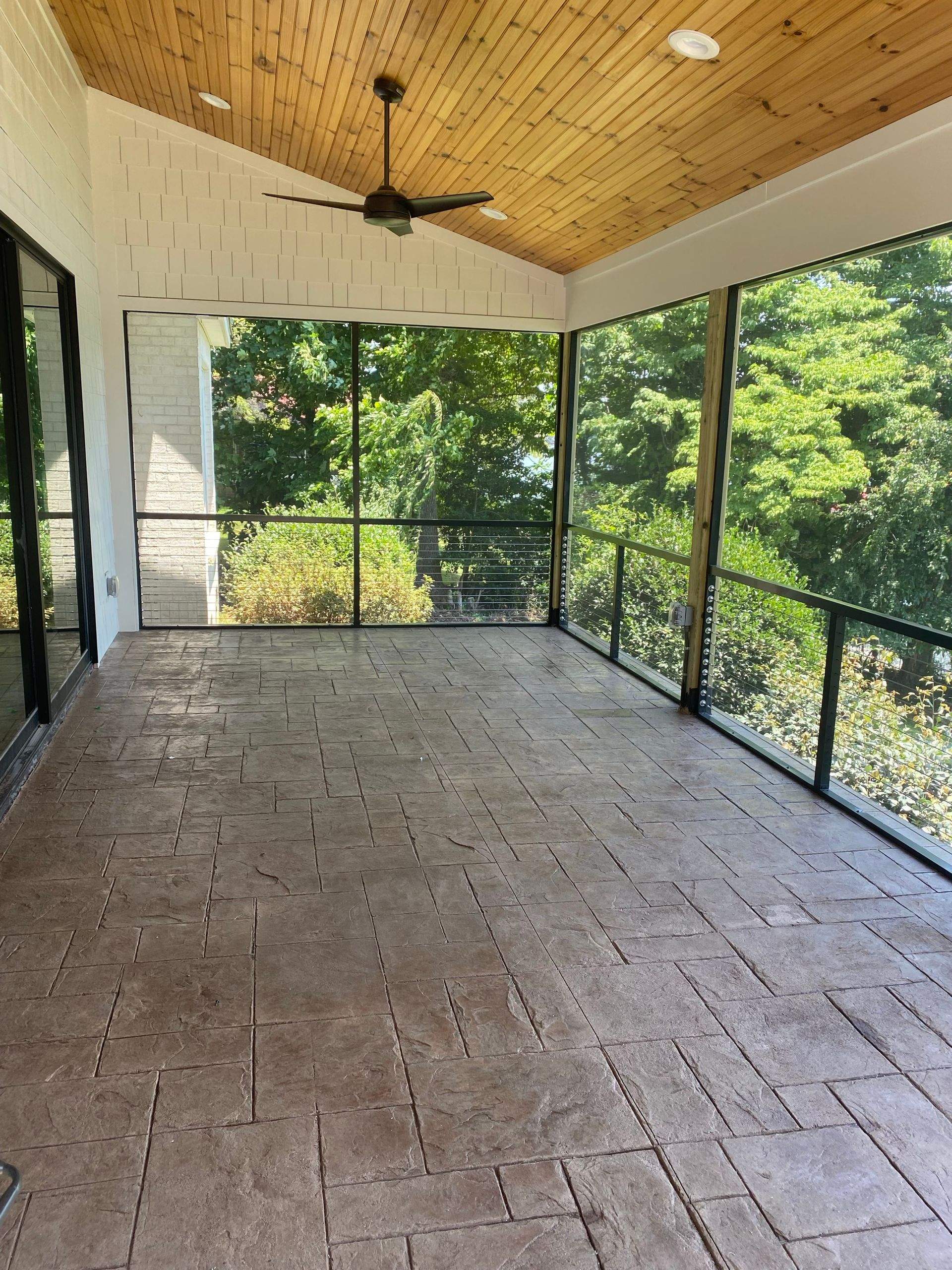 A screened-in porch with cable railings