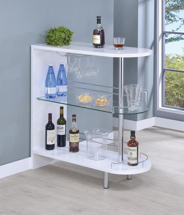 A white bar with wine bottles and glasses on it