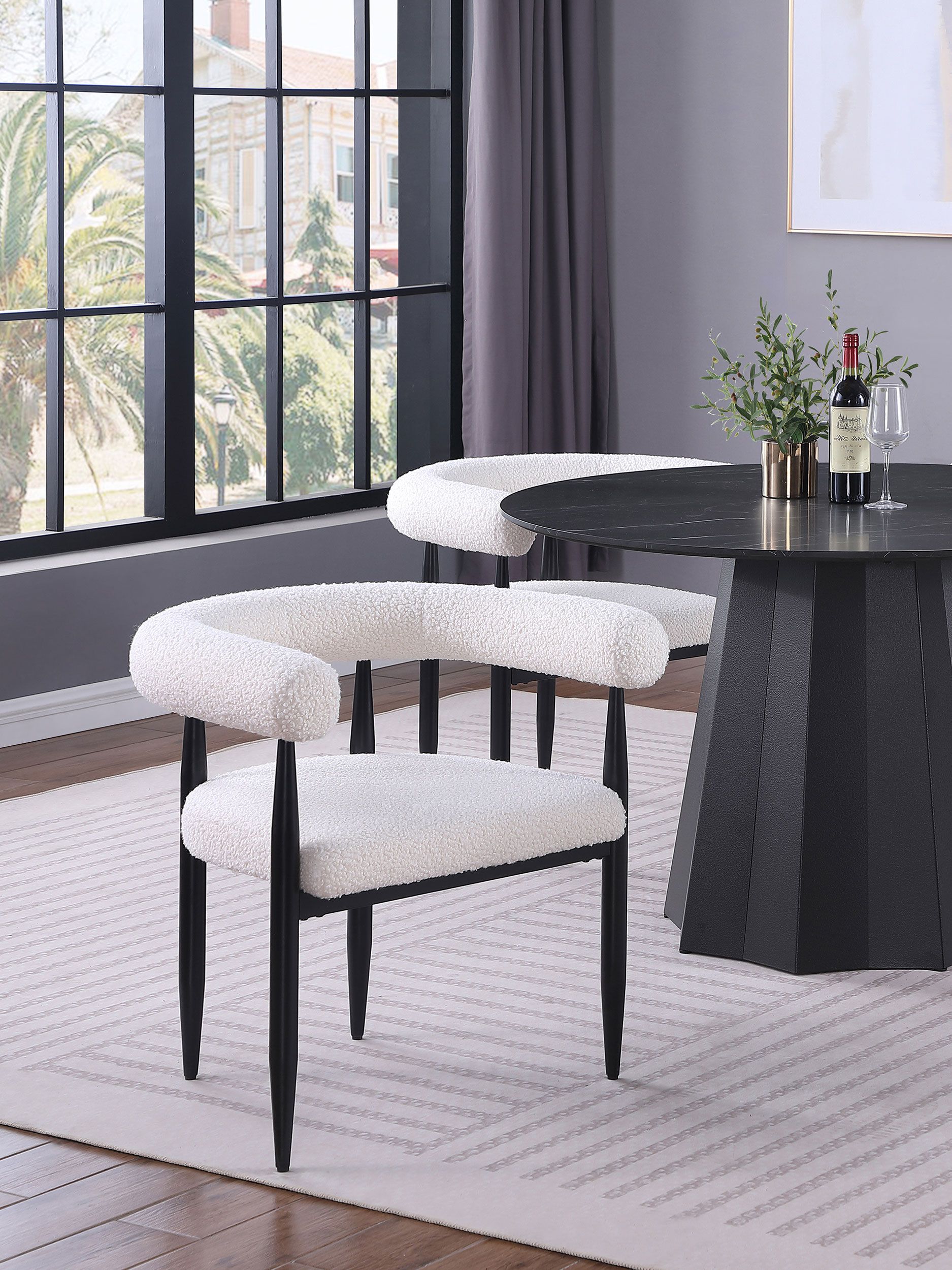A white chair is sitting next to a black table in a living room.