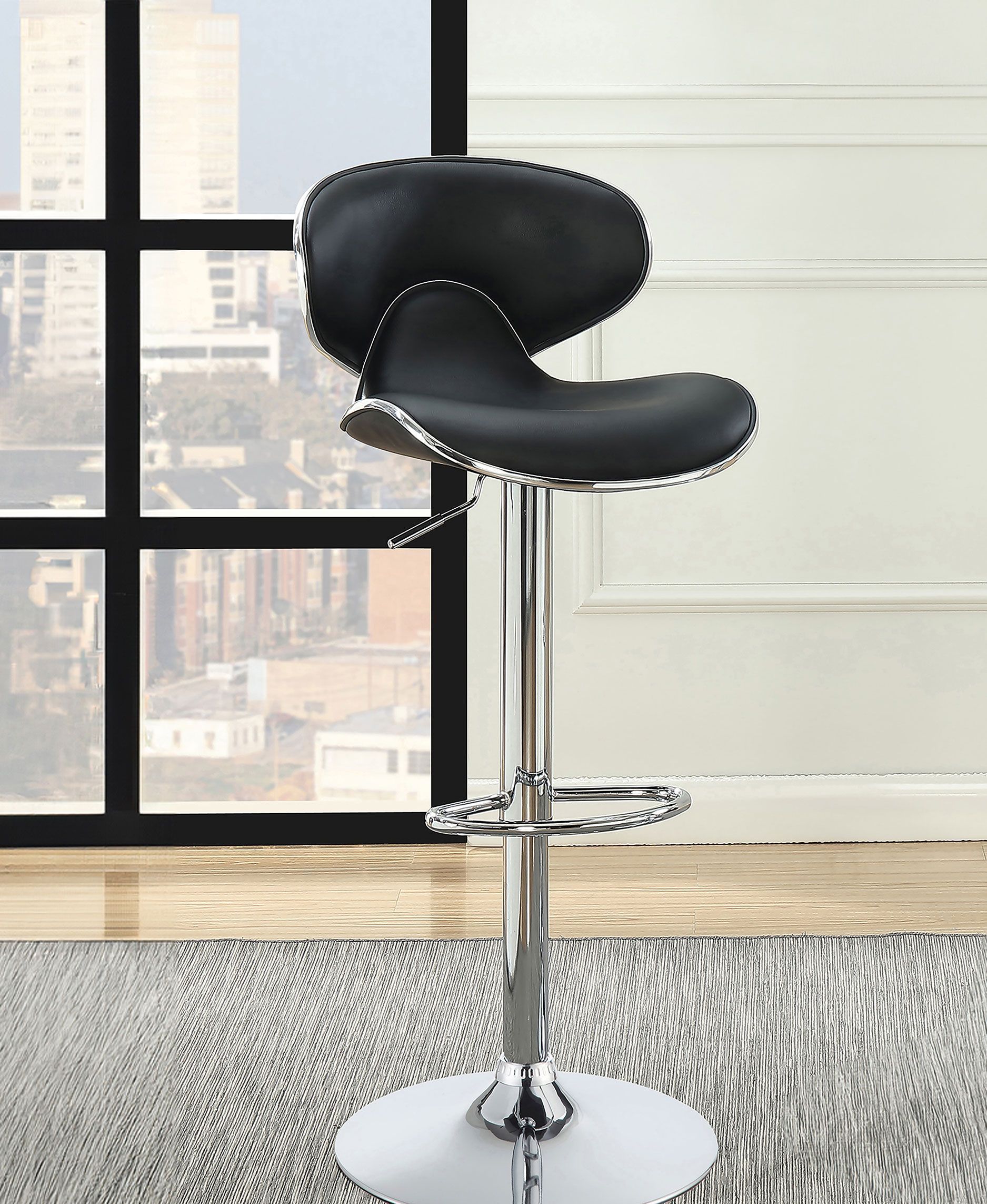 A black bar stool is sitting in front of a window