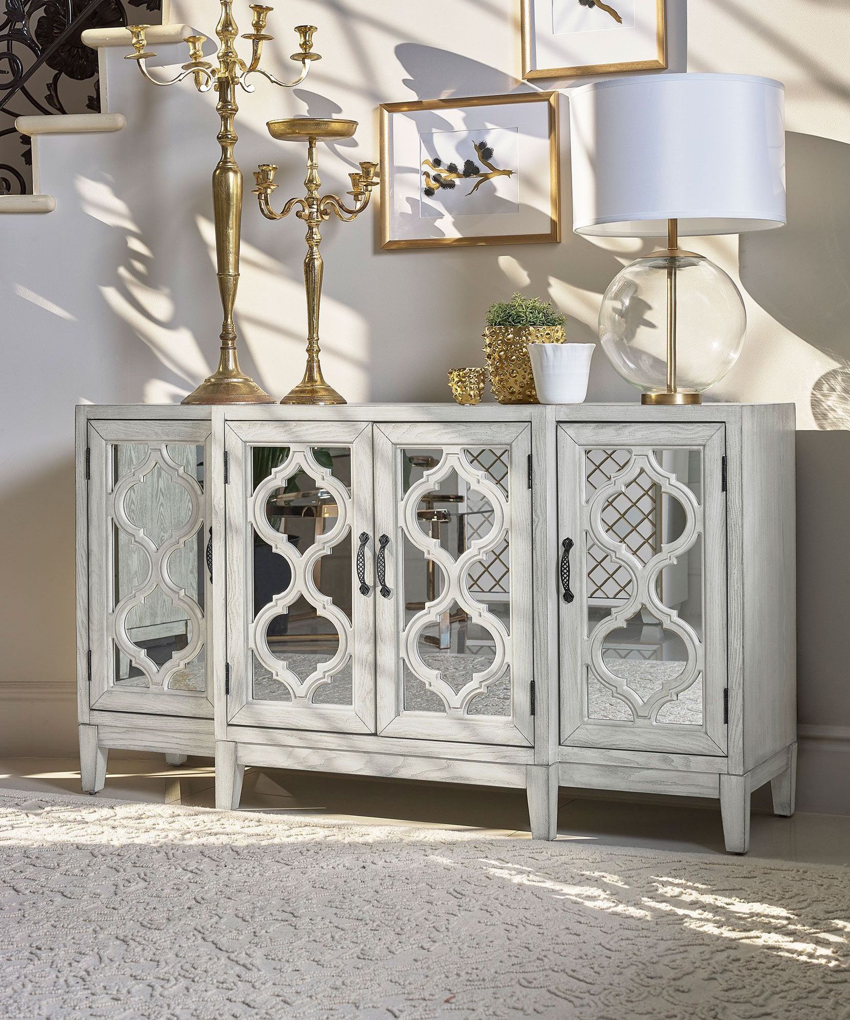 A white cabinet with mirrored doors is in a living room