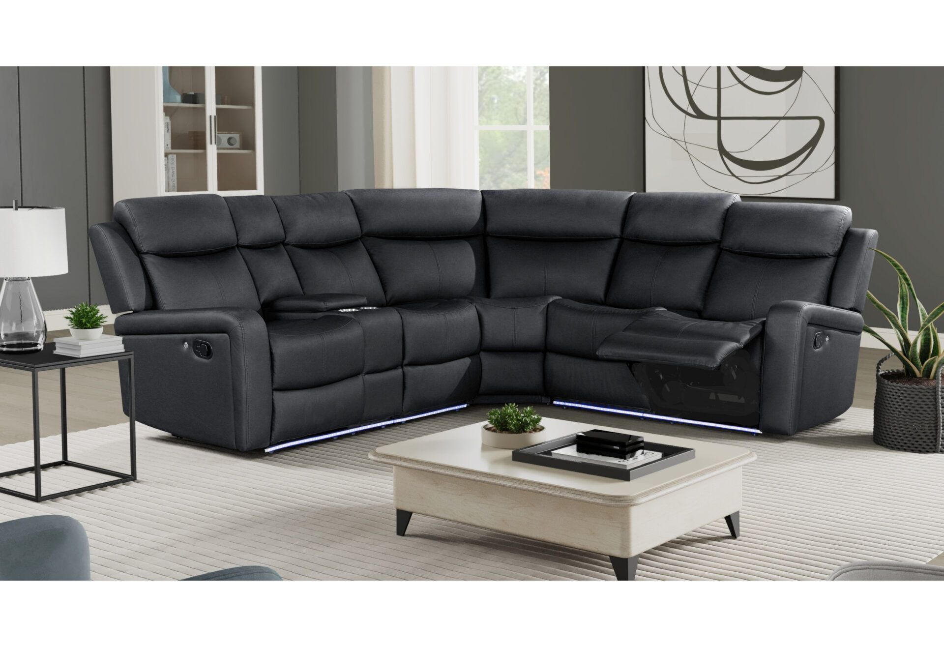 A living room with a black sectional couch and a white coffee table.