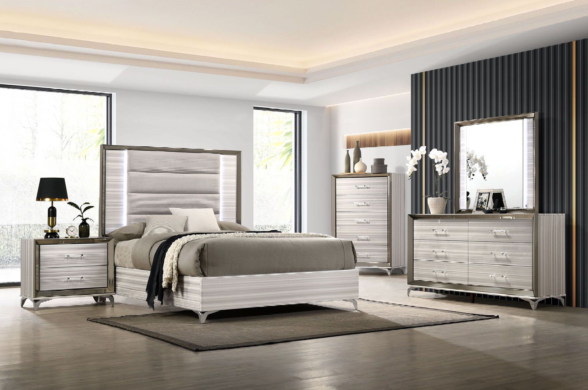 A bedroom with a bed , dresser , nightstand and mirror.