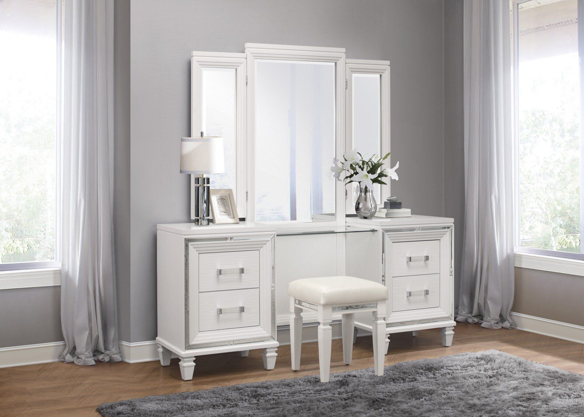 A white vanity with a mirror and stool in a bedroom.