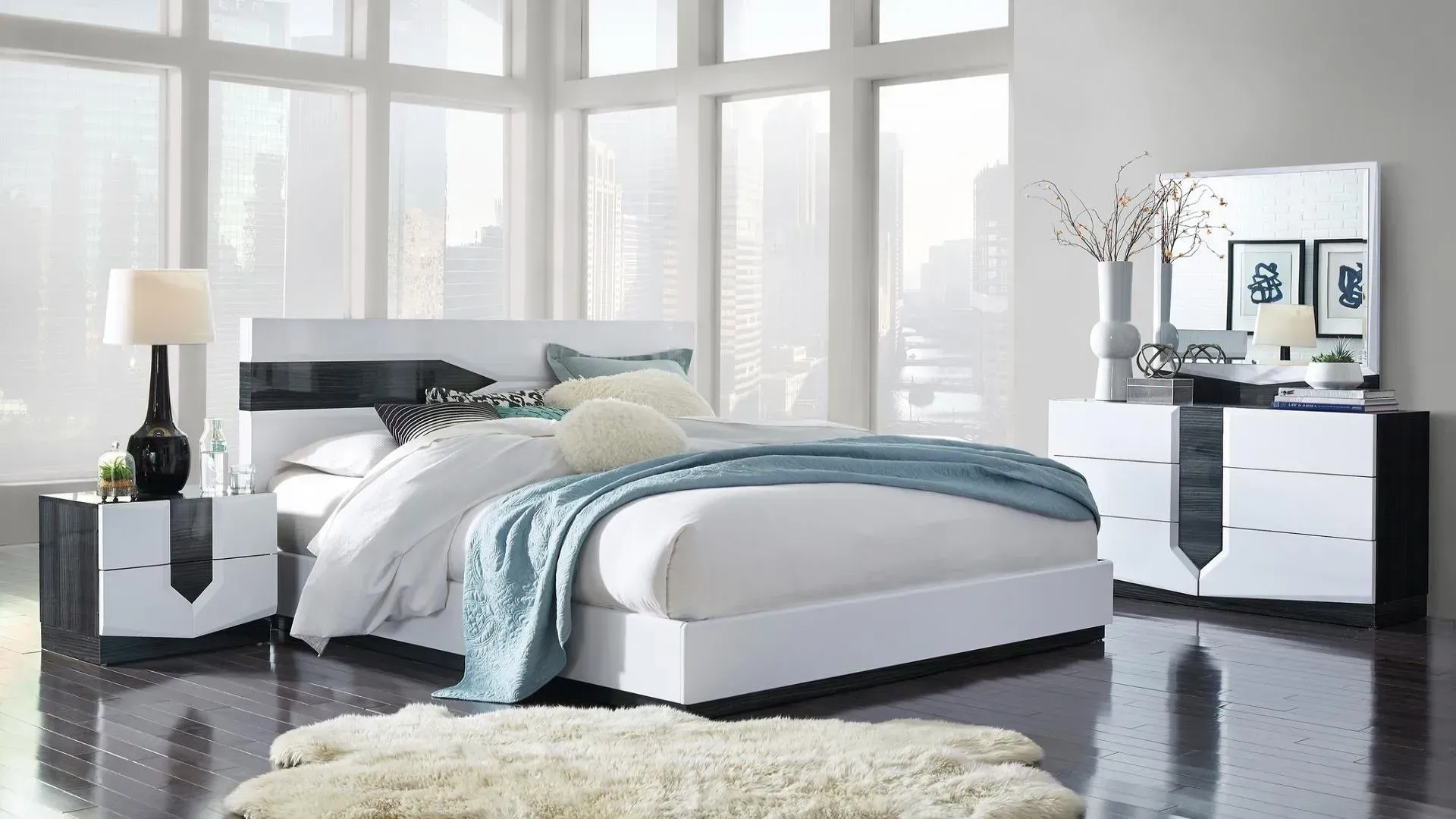 Modern bedroom set with white and black accents. Includes bed, nightstand, dresser, mirror, and shag rug.