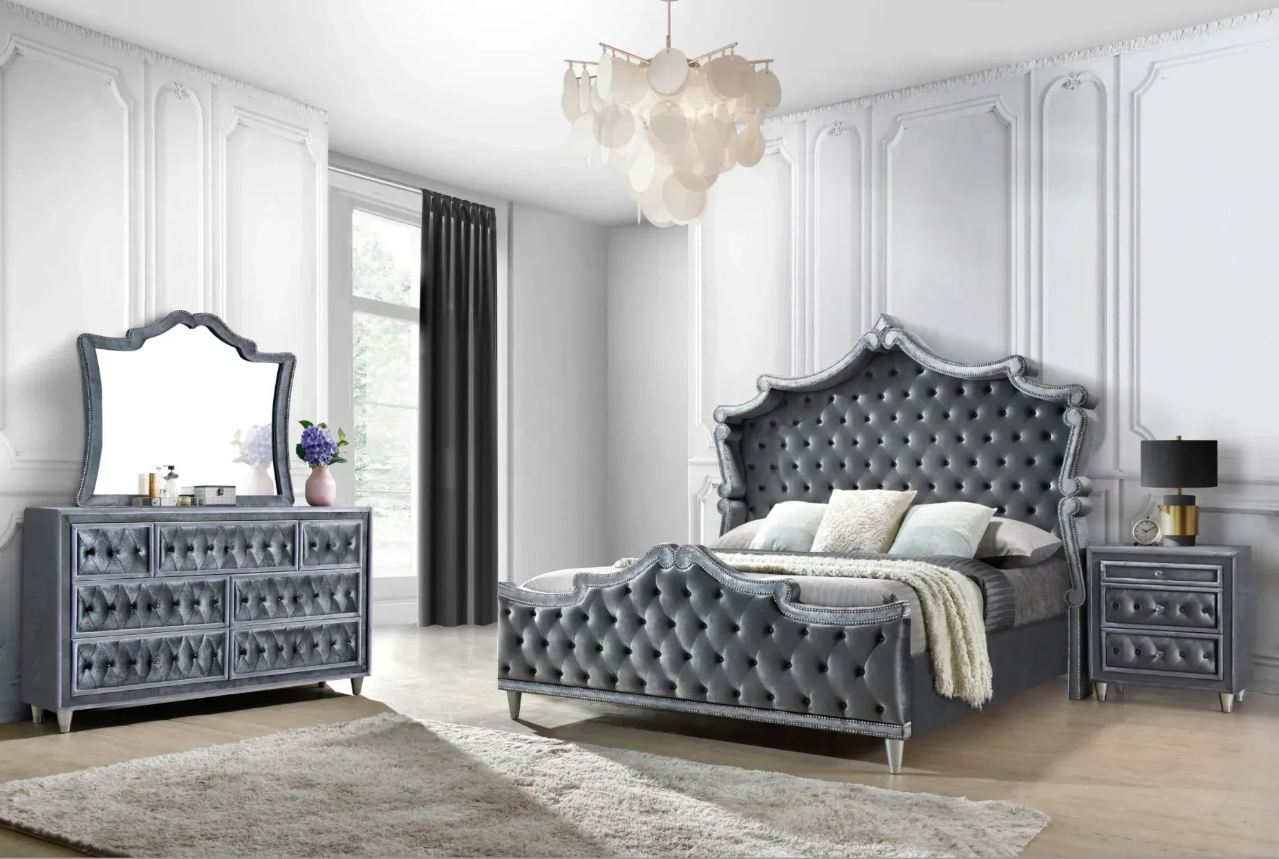Gray velvet bedroom set with tufted bed, dresser, mirror, nightstand, and chandelier.