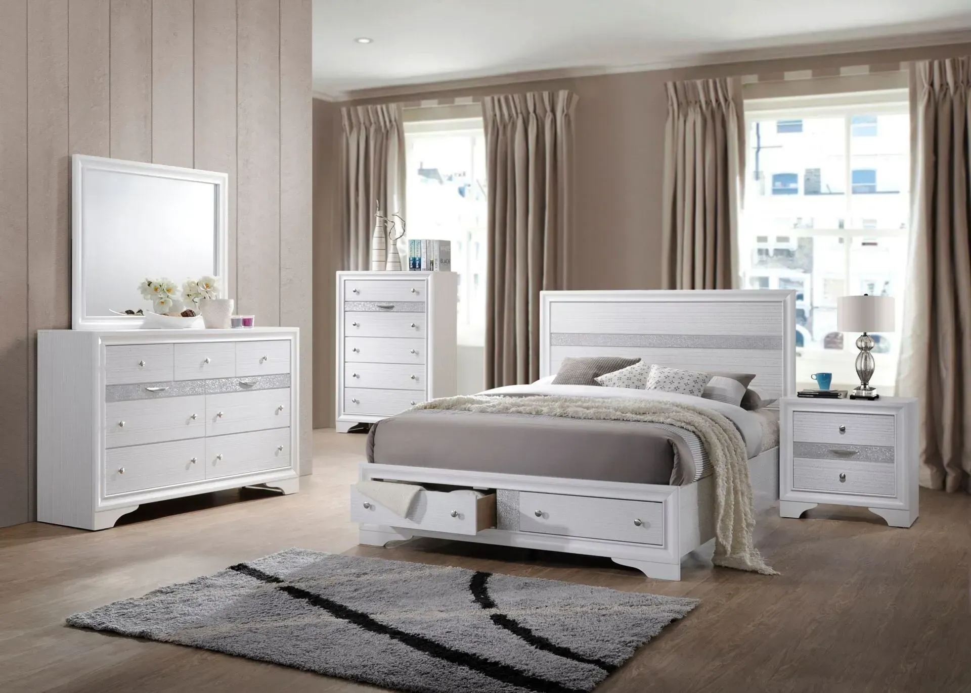 White bedroom furniture set with bed, dresser, chest, mirror, and nightstand. Gray rug.