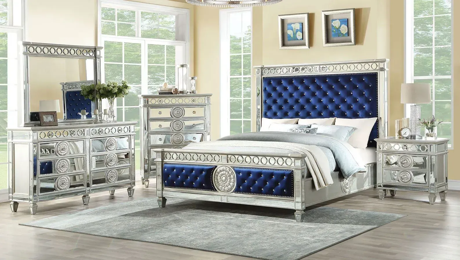 Silver bedroom set with mirrored dresser, chest, nightstand, and bed with blue accents.